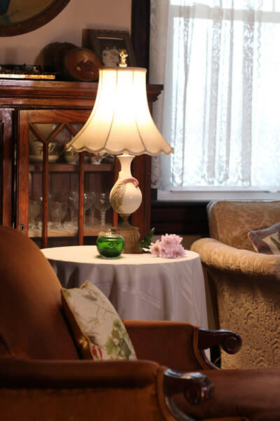 end table with bisque lamp, green glass apple, and mauve fresh flowers